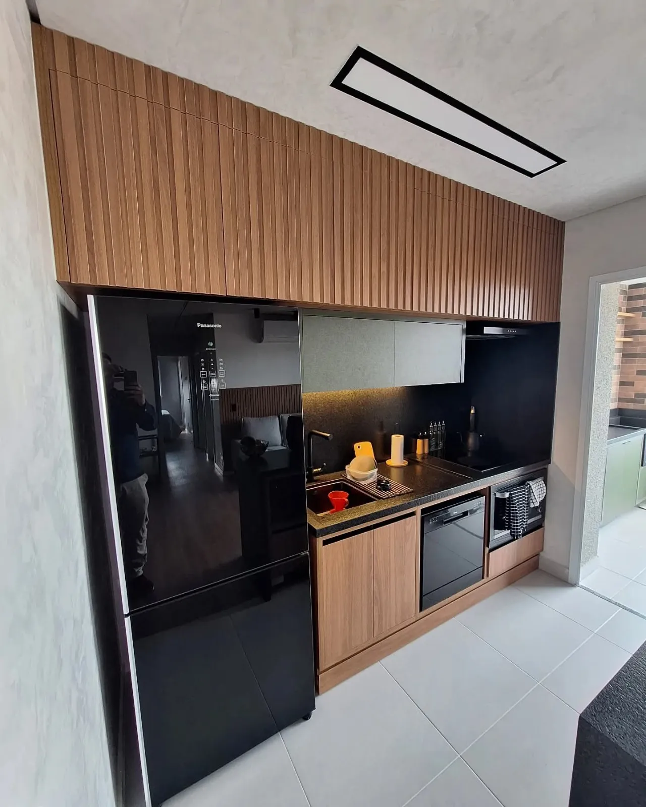 Cozinha compacta planejada em madeira e preto