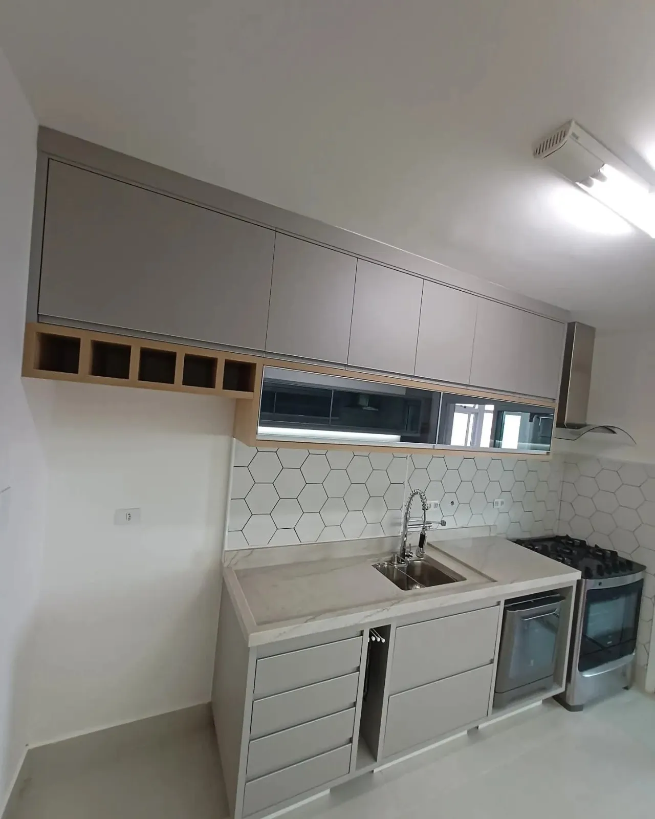 Cozinha compacta clara com armários planejados e nicho para garrafas
