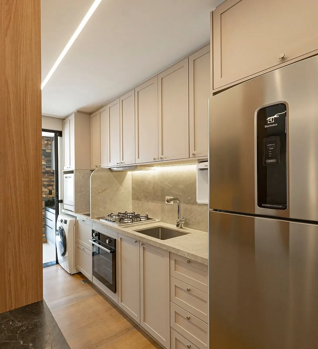 Cozinha planejada com portas clássicas e eletrodomésticos embutidos